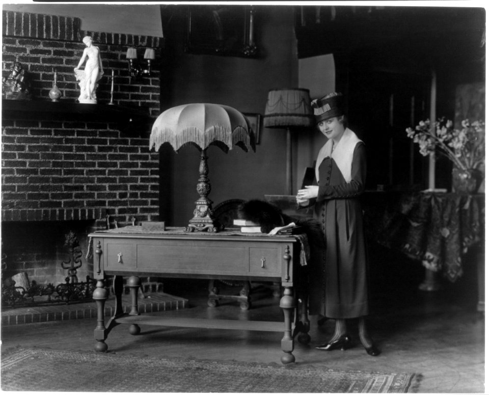 Combination table and folding bed- woman standing alongside table LCCN2004679515