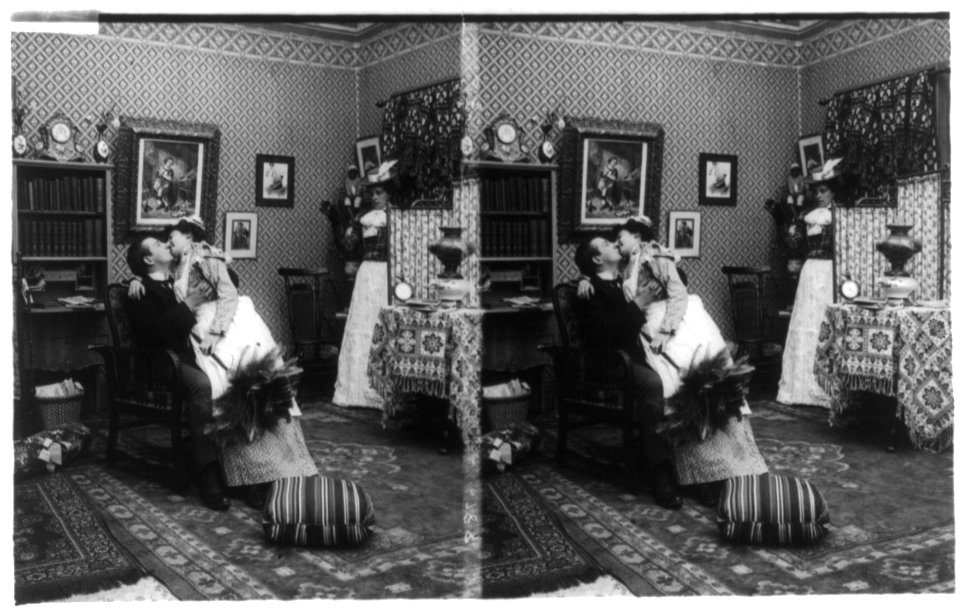 Comical scene showing maid sitting on man's lap kissing him as his wife watches LCCN89710794