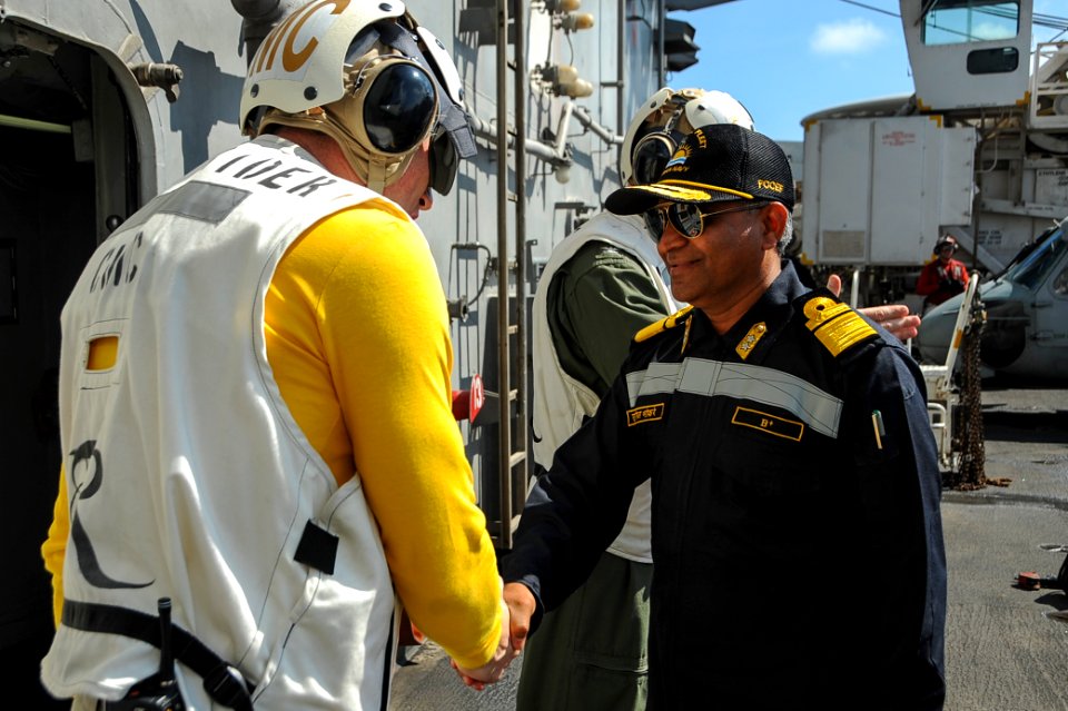 Command Master Chief James Tocorzic, command master chief of the aircraft carrier USS Theodore Roosevelt, greets Rear Adm. SV Bhokare, Flag Officer Commanding Eastern Fleet, Indian Navy