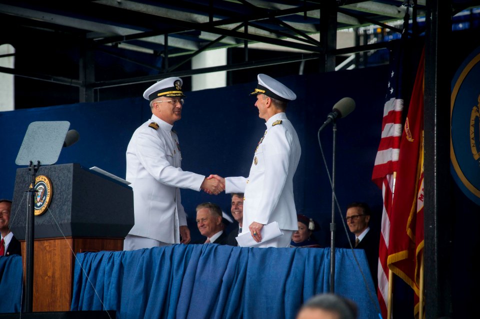 Commandant of Midshipmen U.S. Navy Capt. Robert E. Clark II, standing left, shakes hands with Chief of Naval Operations Adm. Jonathan W. Greenert, standing right, and welcomes him to the stage during the U.S 130524-N-WL435-495