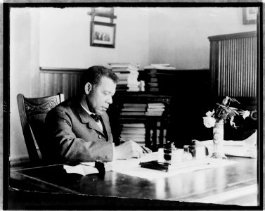 Booker T. Washington, half-length portrait, seated at desk, facing right LCCN98500608