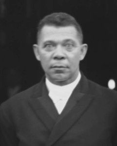 Booker T. Washington standing on the steps of a building, at the Tuskegee Institute's 25th anniversary LCCN2011660897 (cropped) photo