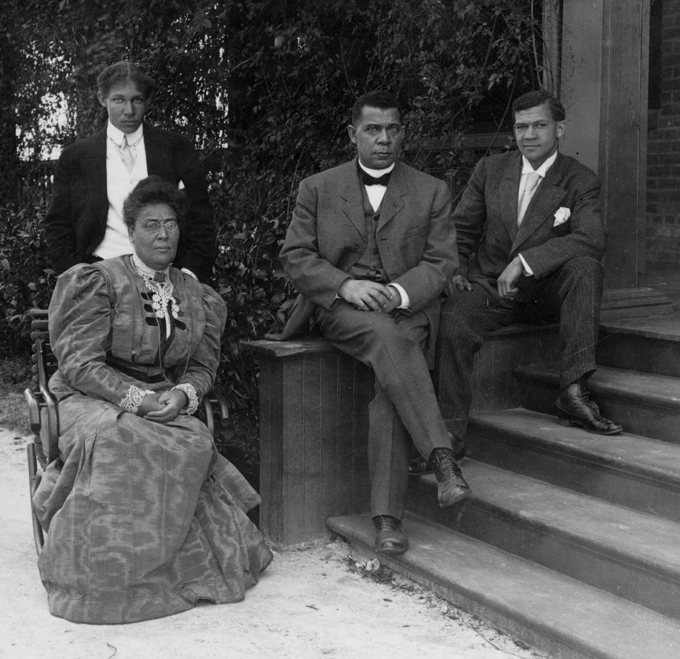 Booker T. Washington, seated on steps of porch, with wife and two sons LCCN91784317 (cropped)