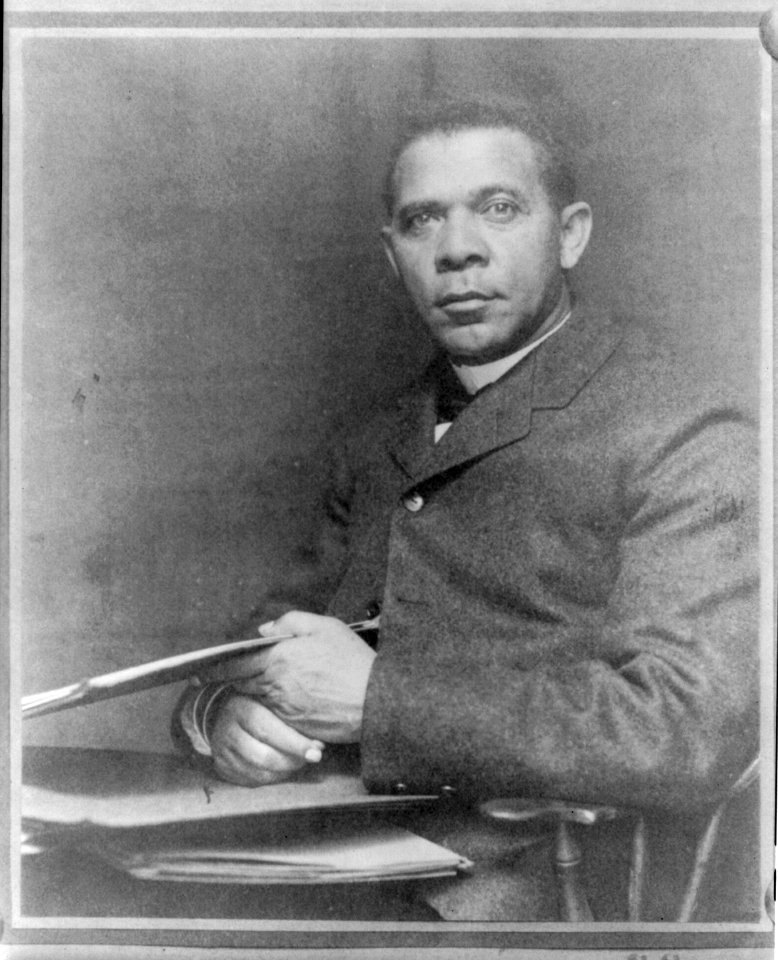 Booker Taliaferro Washington, seated, facing left, with papers LCCN2005687254