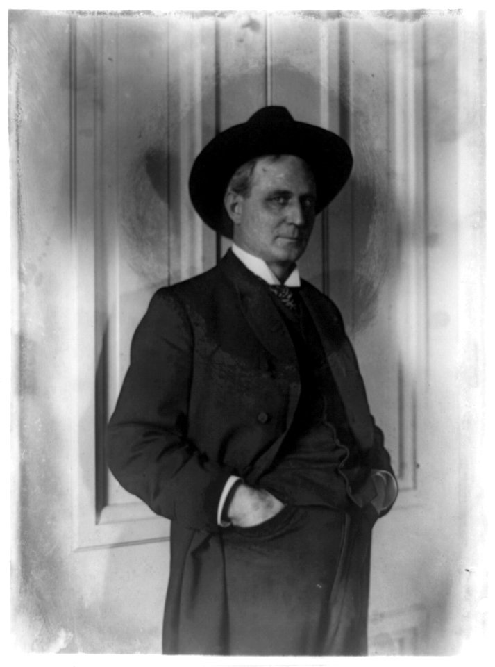 Champ Clark, half-length portrait, standing, facing right, hands in pants pockets LCCN89714542
