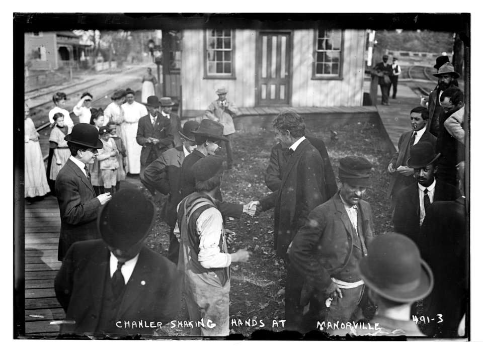 Chanler shaking hands at Manorville (railroad station, during governorship campaign) LCCN2014682358