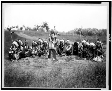 Chief Little Wound in council with other Indians, wearing feather headdresses LCCN90710575