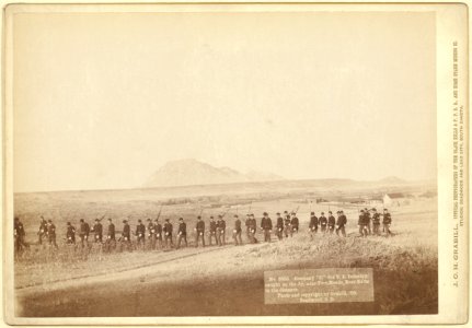 Company C, 3rd U.S. Infantry, caught on the fly, near Fort Meade. Bear Butte in the distance LCCN99613844