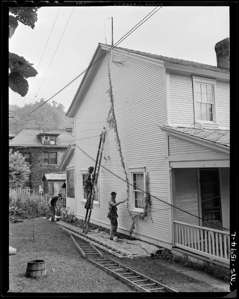 Company employed carpenters and painters work on company owned houses. The houses, streets, community buildings show... - NARA - 540869