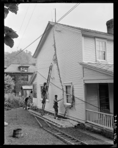 Company employed carpenters and painters work on company owned houses. The houses, streets, community buildings show... - NARA - 540869