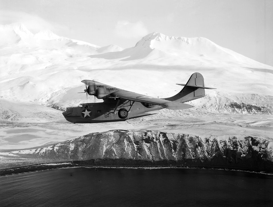 Consolidated PBY-5A Catalina of VP-61 in flight near a snowy Aleutian Island, March 1943 (80-G-475409)