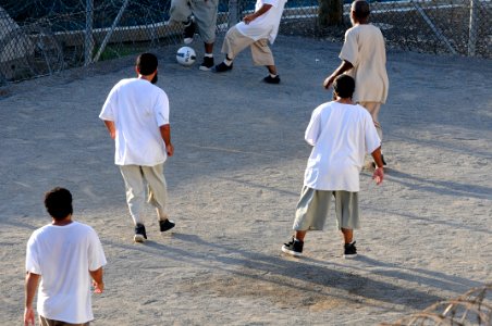 Detainees play soccer in the recreation area of Camp Six at Joint Task Force Guantanamo DVIDS373559