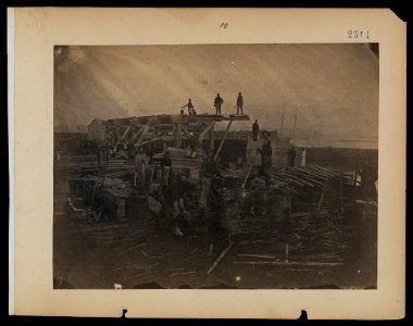 Dockyard at Alexandria, after sunset. Ark builders pitching canvas and laying bottom of ark LCCN2005696802