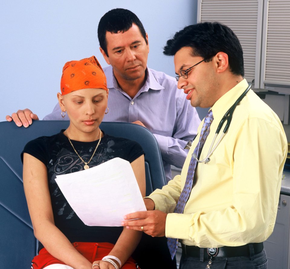 Doctor consults with teenager and father photo