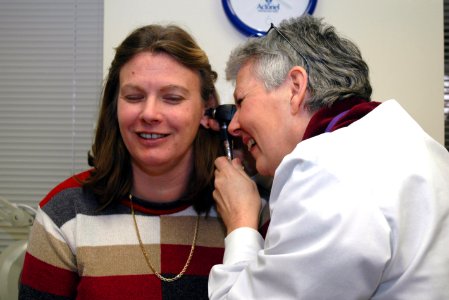 Doctor examines patient's ear photo
