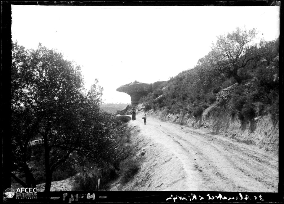 Dona amb un càntir i un nen a la carretera d'Almatret