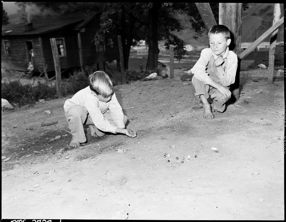 Donald Sergent shooting marbles while a pal looks on. P V & K Coal Company, Clover Gap Mine, Lejunior, Harlan County... - NARA - 541353