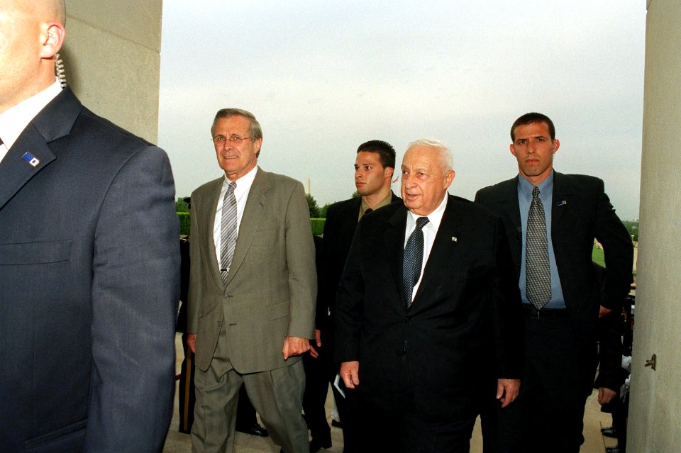 Donald Rumsfeld escorts Ariel Sharon as he arrives at the Pentagon