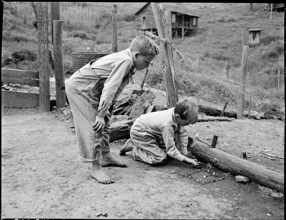 Donald Sergent shooting marbles while a pal looks on. P V & K Coal Company, Clover Gap Mine, Lejunior, Harlan County... - NARA - 541352