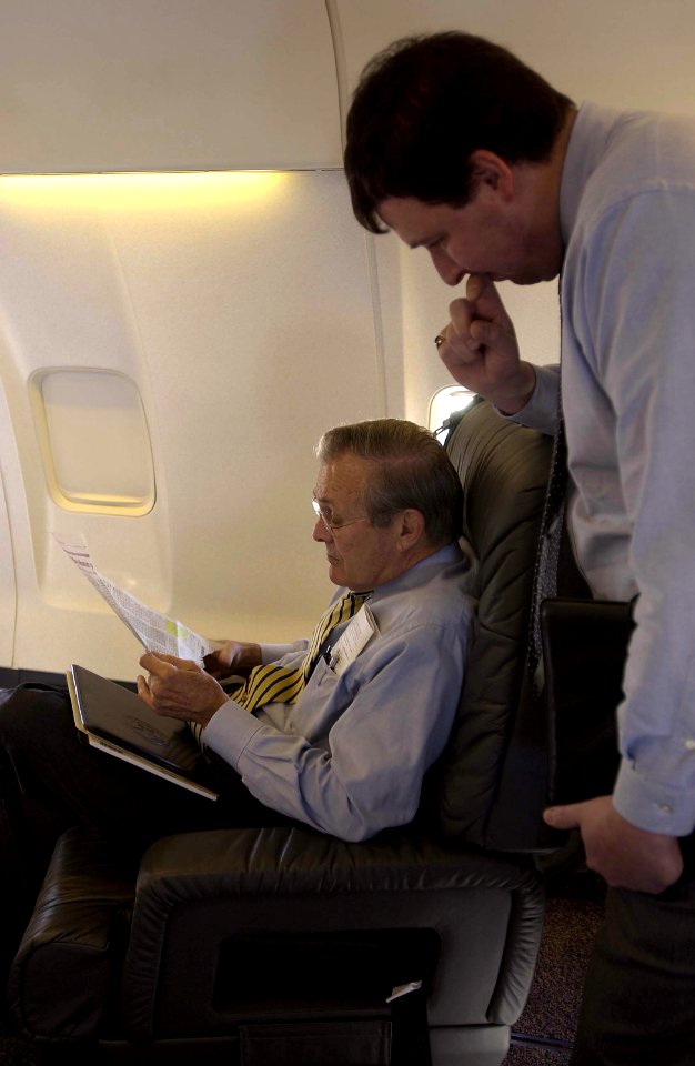 Donald Rumsfeld reviews a news article with Marc Thiessen
