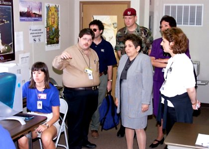 Donna Shalala observes a young Kosovo girl sitting in front of an iMac