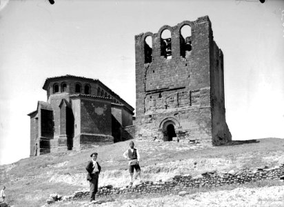Dos homes davant una torre i l'església de la Asunción de Nuestra Señora