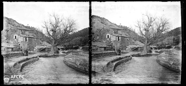 Dos homes en un camí a la vora de la rasa de Sociats i al fons el molí del Pont