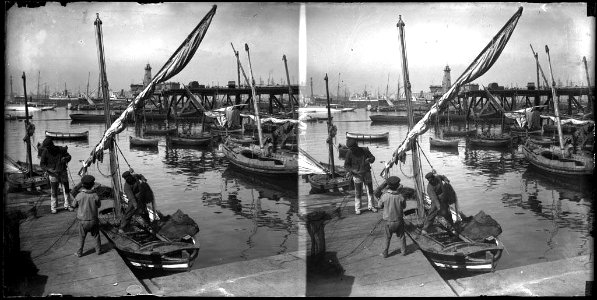 Dos homes i un nen posant a punt una barca al port de Barcelona