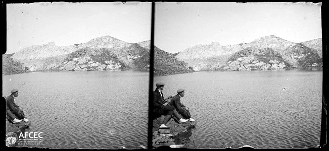 Dos homes en una roca a la riba de l'estany Blau de Carançà
