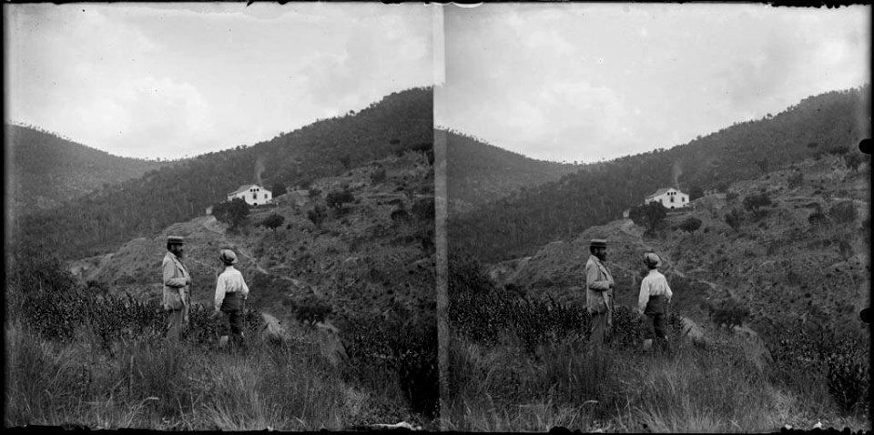 Dos homes i al fons una masia i un bosc