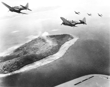 Douglas SBD-5 Dauntless of VB-16 fly low over Param Island, Truk Atoll, 17-18 February 1944 (NNAM.1996.253.688)