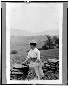 Dr. Clara Barrus seated on stone fence at Woodchuck Lodge LCCN91784657