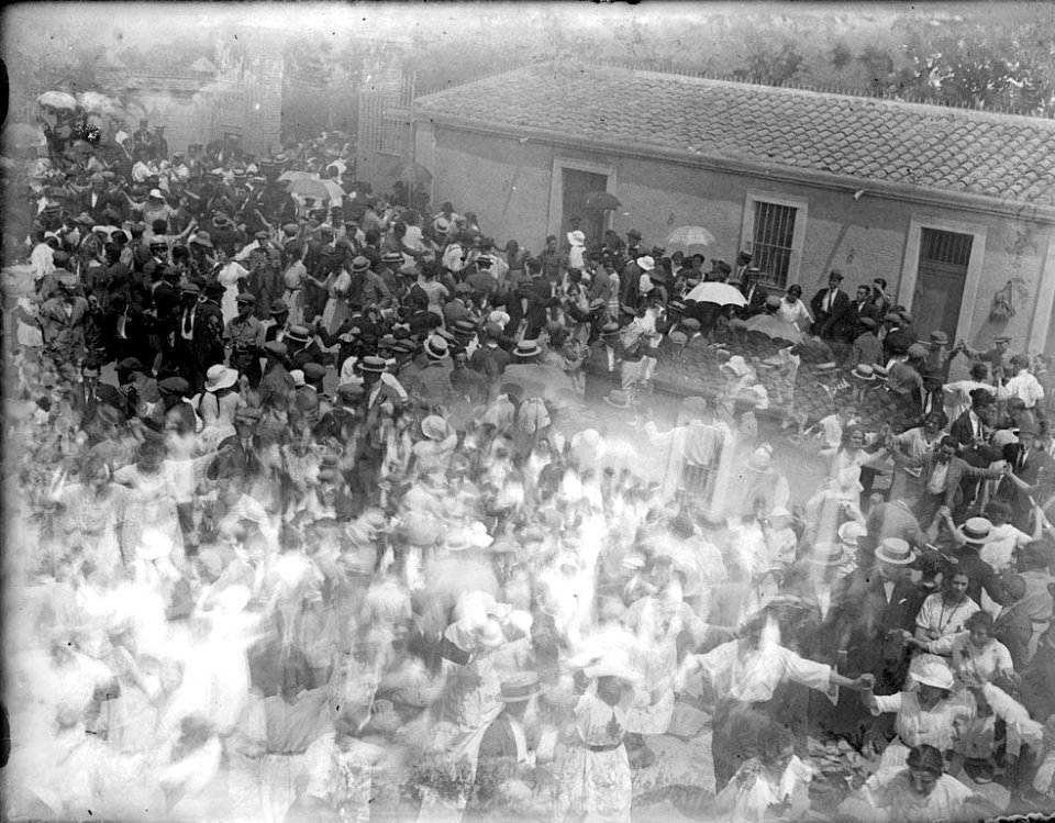 Dues imatges sobreposades, reunió festiva a la plaça d'un poble i una casa (AFCEC RIBASV C 2699)
