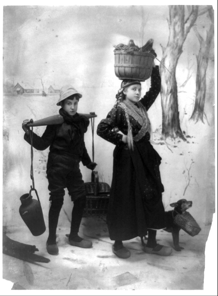 Dutch girl, boy and dog carrying supplies in snow LCCN2003675184