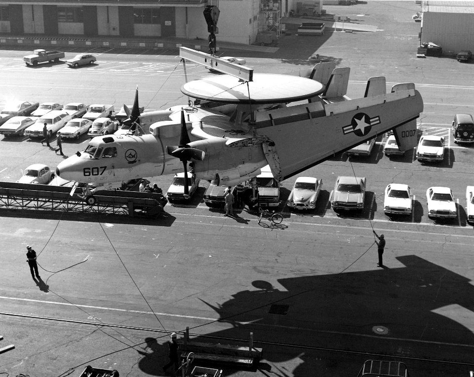 E-2C of VAW-122 is hoisted aboard USS Kitty Hawk (CV-63) at North Island in 1977