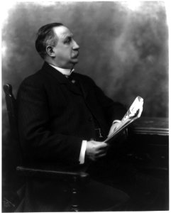 E.P. Shaw, three-quarters length, seated, holding newspaper LCCN2007682442