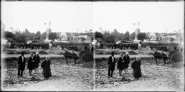 Gent i carros a la riera i al fons el poble de Cardedeu