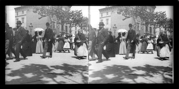 Gent passejant per la rambla de Catalunya i al fons l'armeria Estruch