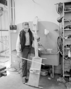 George Cedric Wright playing a double bass type instrument built for him at Lawrence Radiation Laboratory - NARA 22118130