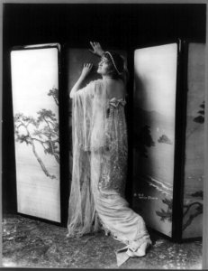 Gaby Deslys, 1884-1920, full length, standing, facing left, arms against folding partition LCCN2005693308