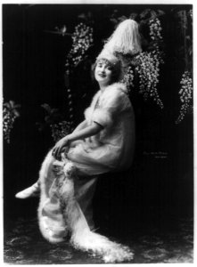 Gaby Deslys, 1884-1920, full length portrait, seated, facing slightly left in ornate hat and dress LCCN2005693311
