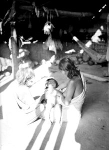 Gammal medicinkvinna botar ett barn som dess moder håller i knät - SMVK - 004914 photo