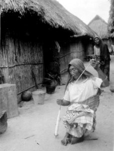 Gata i byn med kvinna som spinner bomullstråd på slända. San Blas. Panama - SMVK - 004452