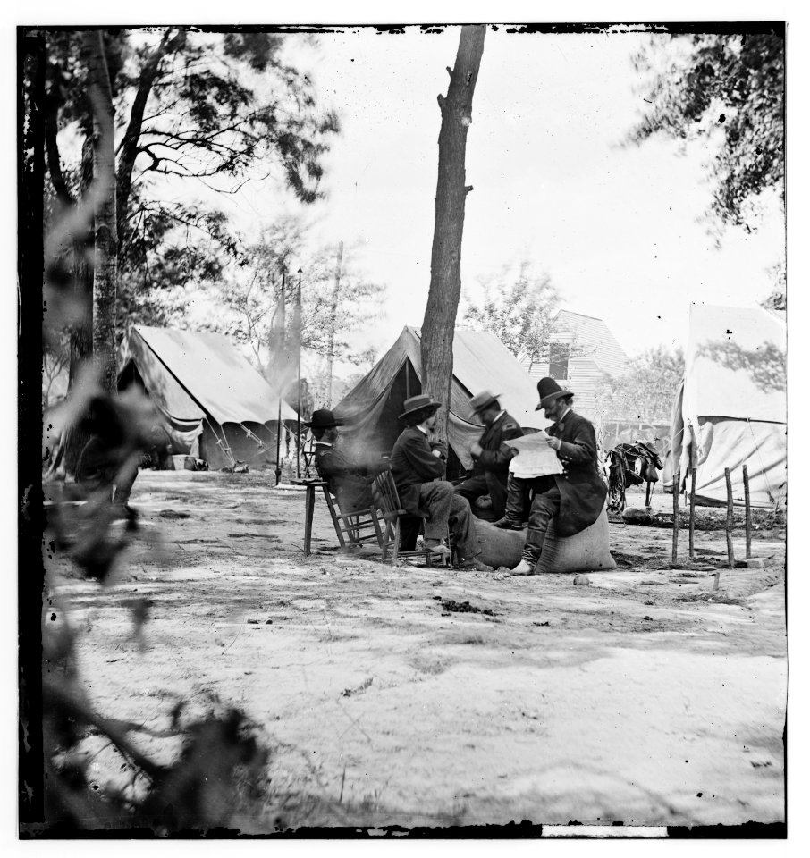 Gen. Ambrose E. Burnside (reading newspaper) with Mathew B. Brady (nearest tree) at Army of the Potomac headquarters LOC cwpb.01702