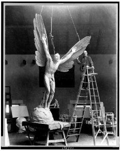 Gutzon Borglum, sculptor, full-length portrait, standing on ladder, alongside his sculpture, Statue of Aviator, facing slightly left LCCN92513935