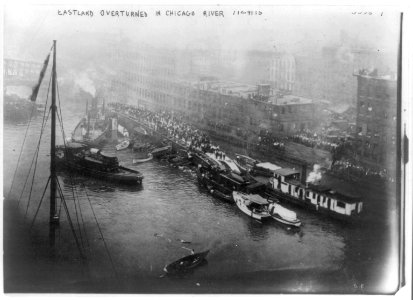 EASTLAND disaster; excurion boat overturned in Chicago River with passengers standing on upturned port side; many small boats assisting in rescue operations while crowds watch from shore closeby. LCCN2017658559