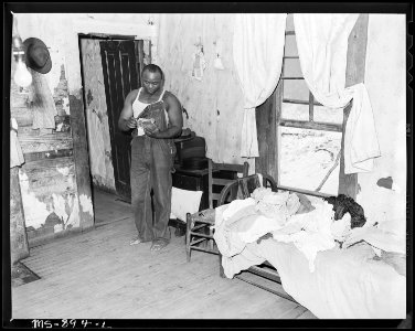 Eddie Cain, miner, looking over his bills in his home in company housing project. Adams, Rowe & Norman Inc., Porter... - NARA - 540596
