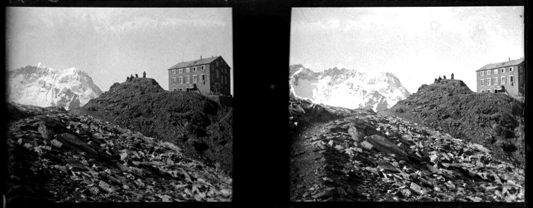 Edifici amb alguna gent i al fons muntanyes nevades