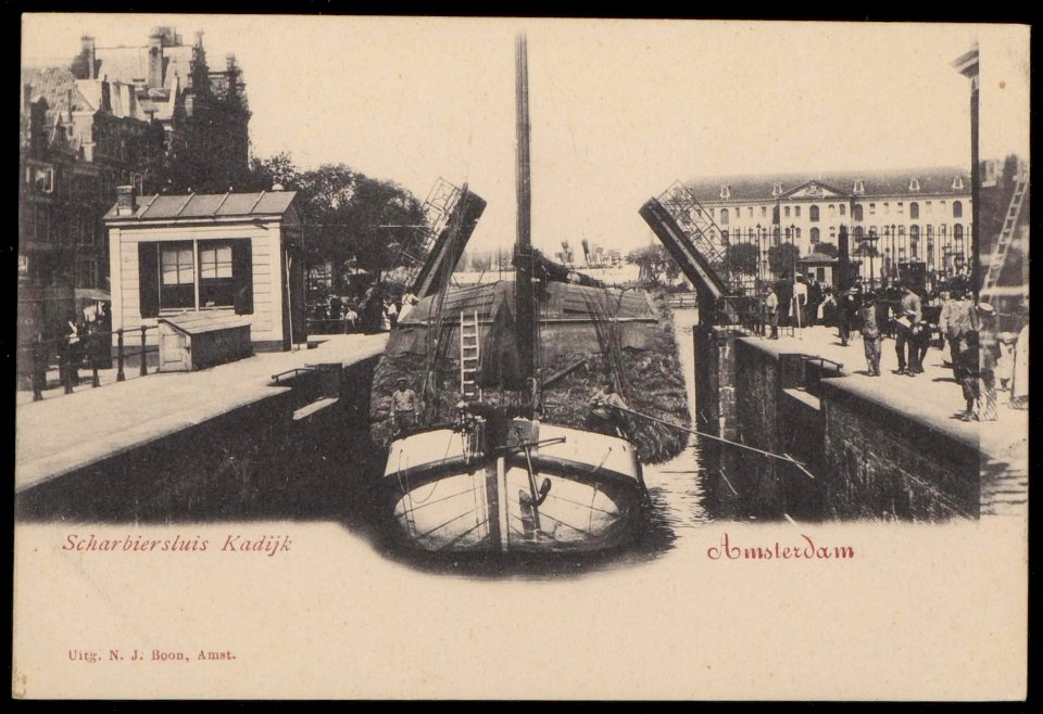 Een hooggeladen tjalk vaart van de Schippersgracht de Scharrebiersluis in richting Oosterdok