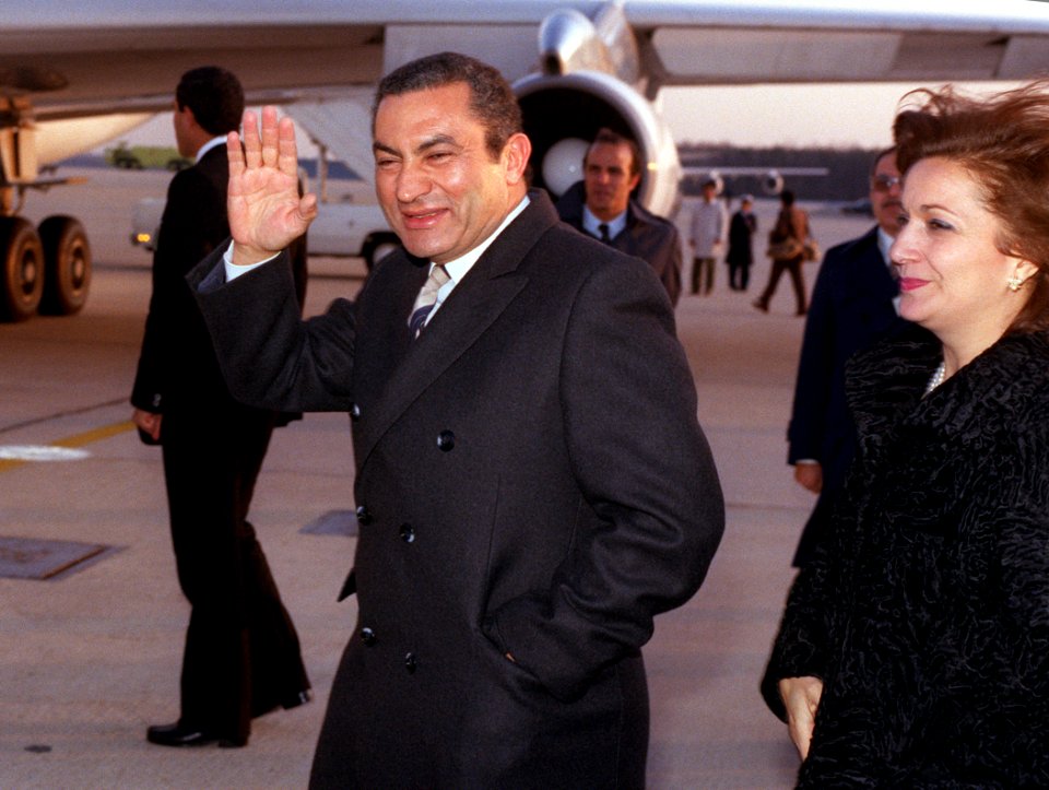 Egyptian President Hosni Mubarak waves to spectators while boarding a plane after a visit to Washington D.C
